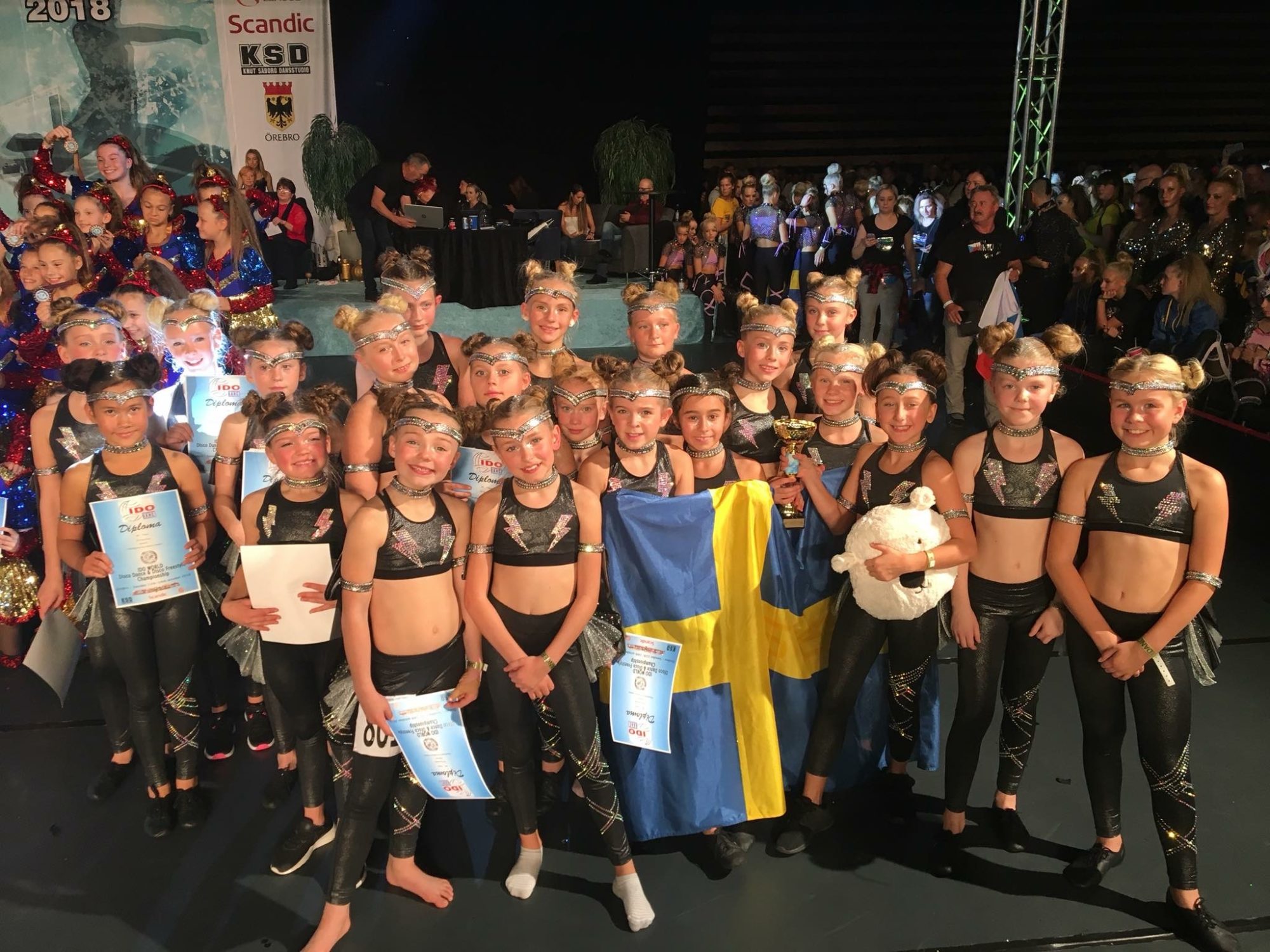 Tävlingsdansare med svensk flagga och diplom